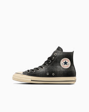 Side profile of a black All Star aged high-top canvas sneaker with an aged cream sole and circular ankle patch.