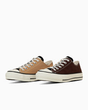 Two low-top canvas sneakers (one beige, one dark brown) shown side-by-side on a white background.