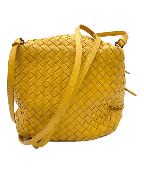 Yellow intrecciato (woven) cow leather shoulder bag with a long adjustable strap visible from the front.