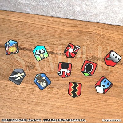 Several small status effect flake stickers with colorful icon designs arranged on a wooden surface.