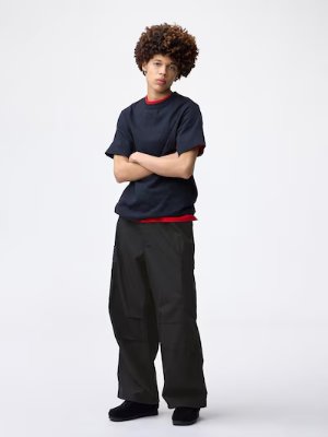 A model standing with arms crossed wearing the men's super-wide cargo pants.
