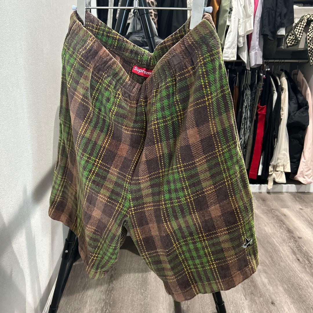 Brown and green plaid velour Supreme 19SS shorts hanging on a hanger with a red Supreme tag visible.